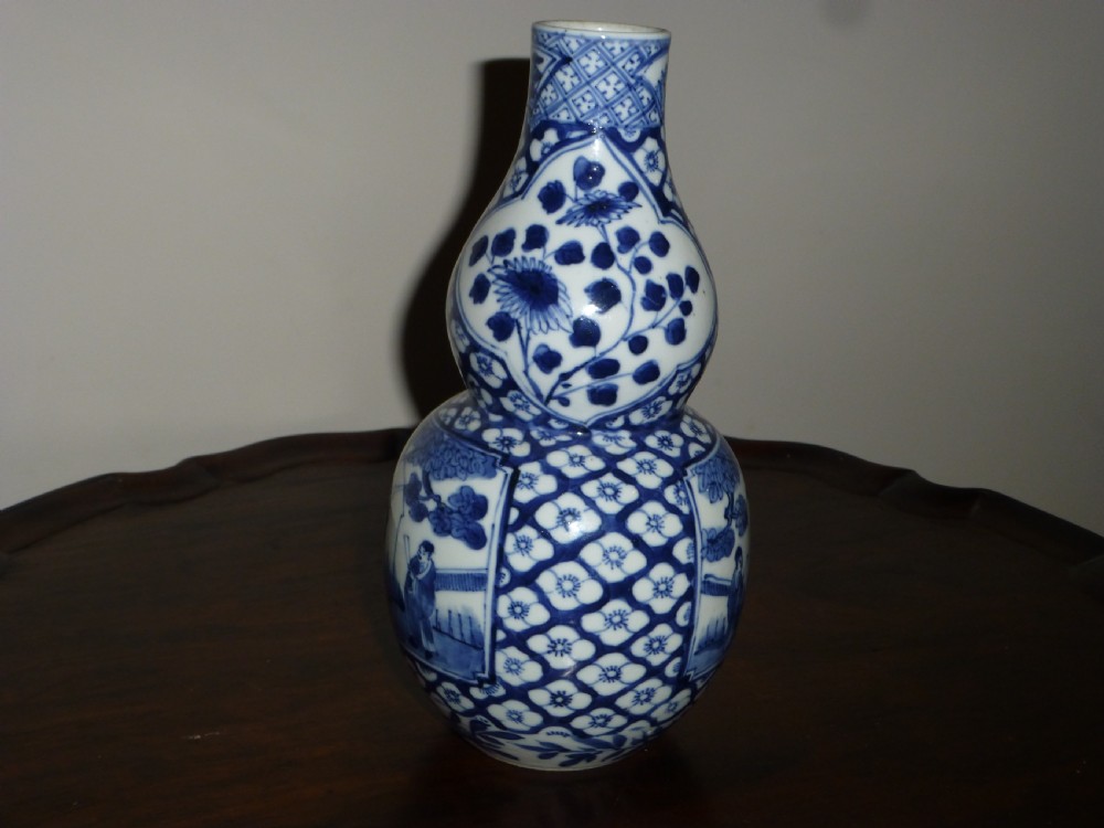 A Chinese blue and white porcelain double gourd vase decorated with figurative cartouches and floral diaper patterns. View III