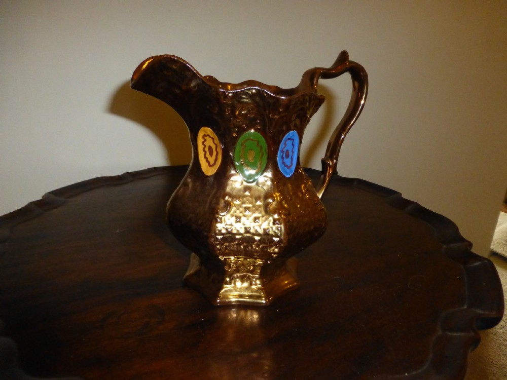 A Victorian copper lustre ceramic milk jug featuring a scalloped rim, scroll handle, and hand-painted enamel oval motifs in yellow, green, and blue. View III
