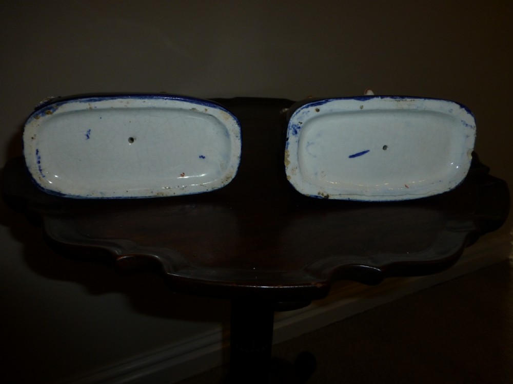 A pair of white textured Victorian Staffordshire ceramic poodles seated on cobalt blue bases with two small puppies beside each. View III