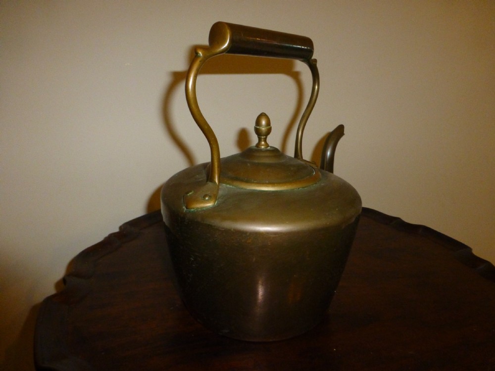 A George III Georgian copper tea kettle featuring an acorn finial, a curved gooseneck spout, and a fixed overhead handle. View II