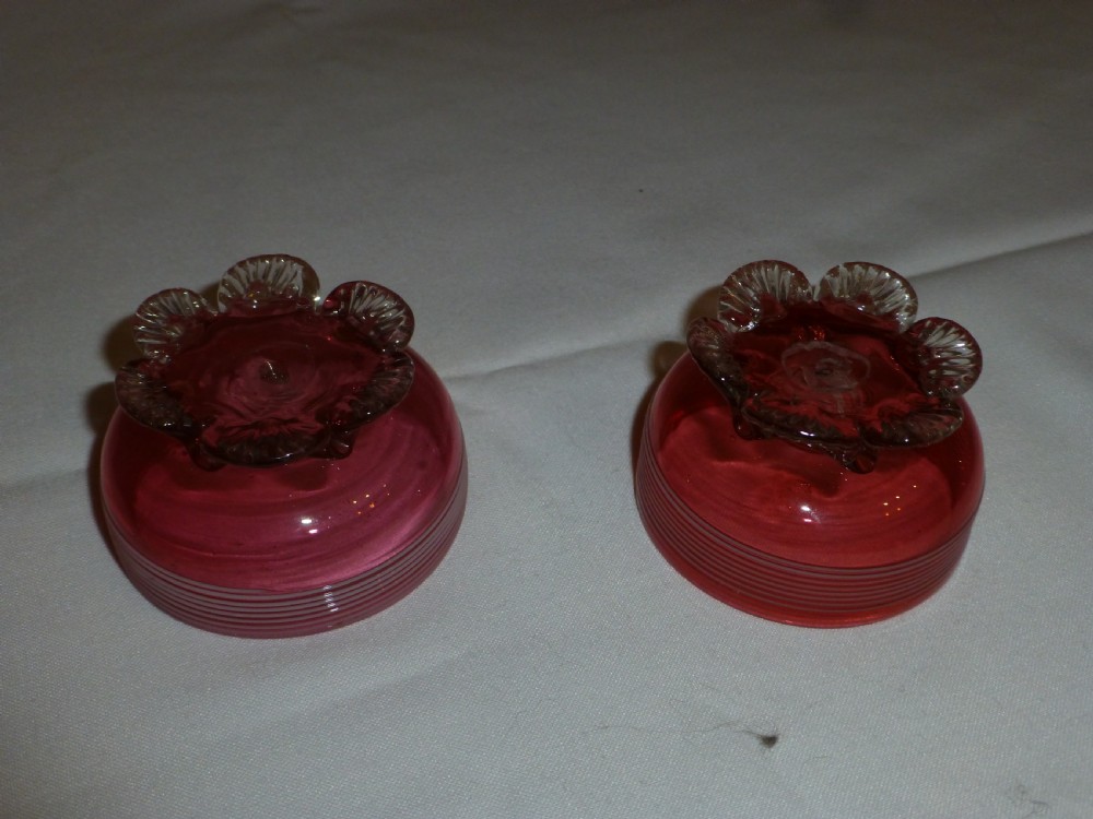 A pair of Victorian cranberry glass salt cellars featuring white horizontal glass trailing and shell-moulded feet. View II