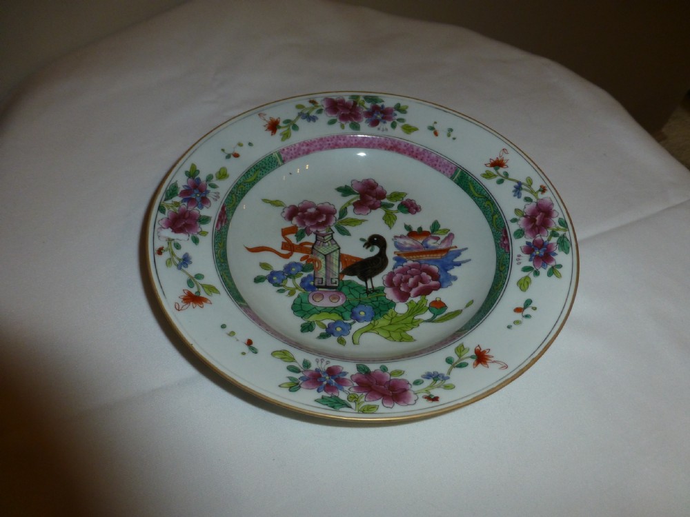 An 18th century Chinese Qianlong period famille rose porcelain shallow bowl decorated with hand-painted floral sprays and a central bird motif.