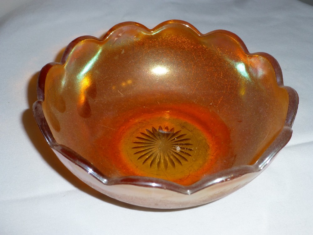 An amber carnival glass bowl featuring a scalloped rim and a metallic iridescent sheen with a textured exterior. View II