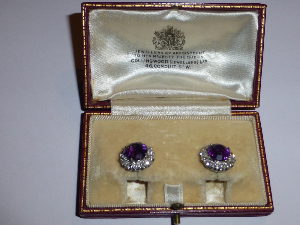 A pair of round white gold stud earrings featuring central purple amethysts encircled by brilliant-cut diamonds. View IX