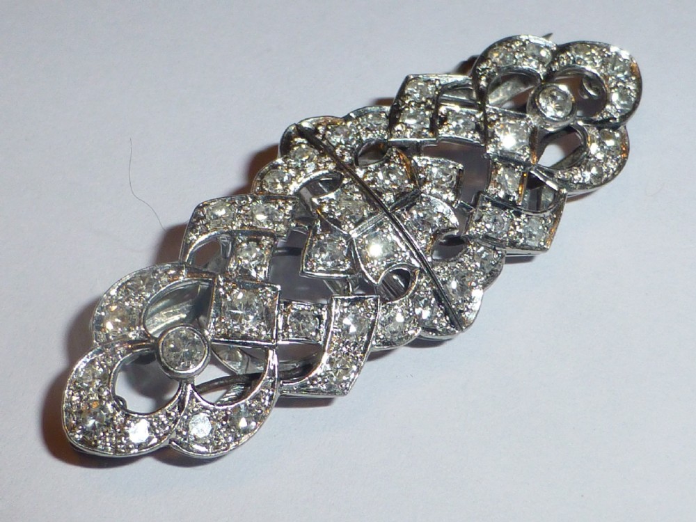 An Art Deco platinum and diamond double clip brooch featuring intricate geometric openwork set with round diamonds. View II