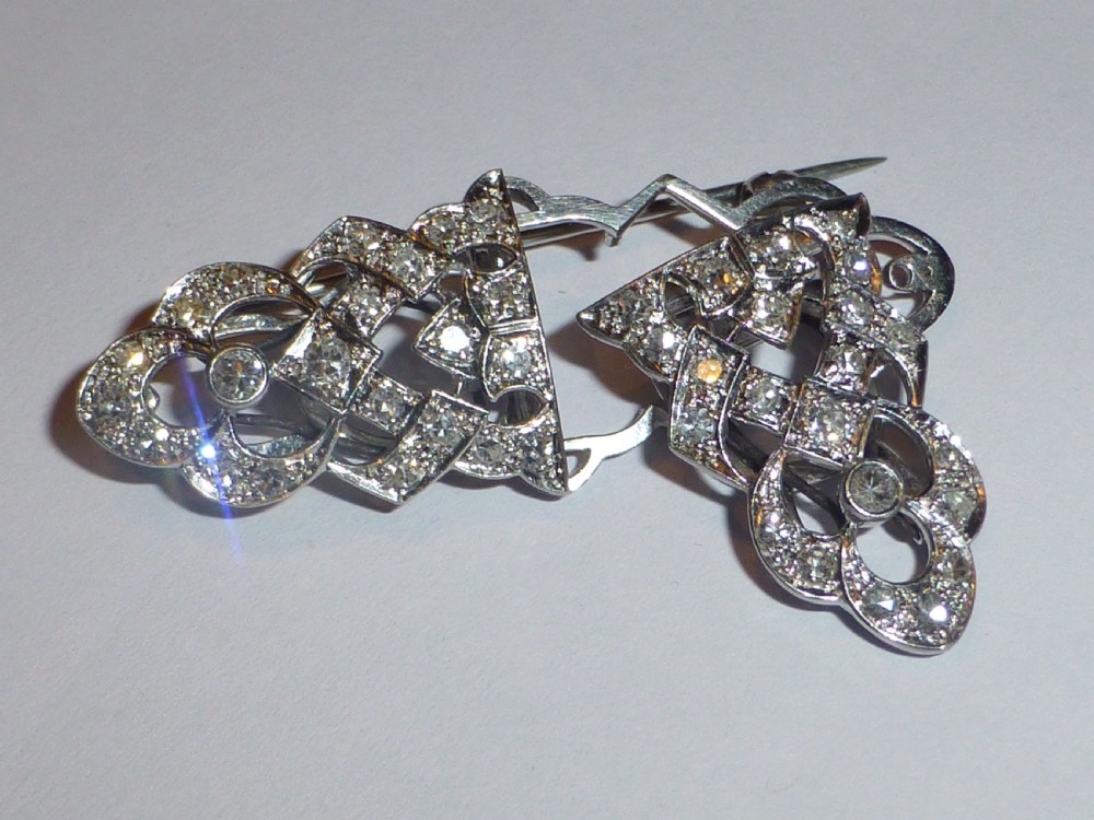 An Art Deco platinum and diamond double clip brooch featuring intricate geometric openwork set with round diamonds. View III