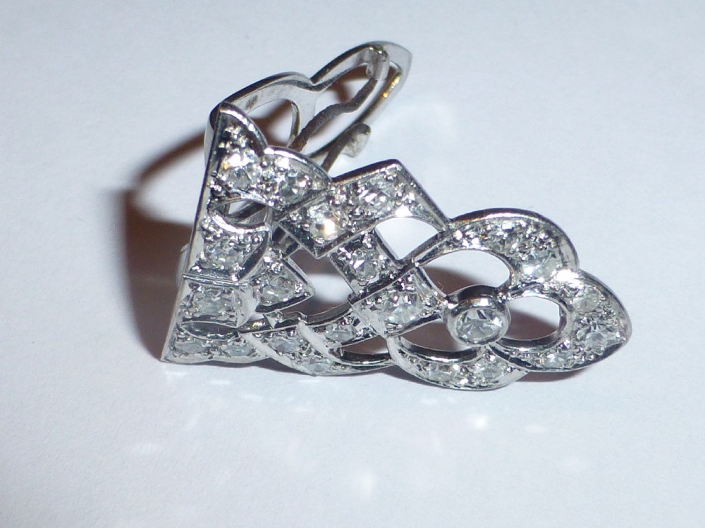 An Art Deco platinum and diamond double clip brooch featuring intricate geometric openwork set with round diamonds. View IV