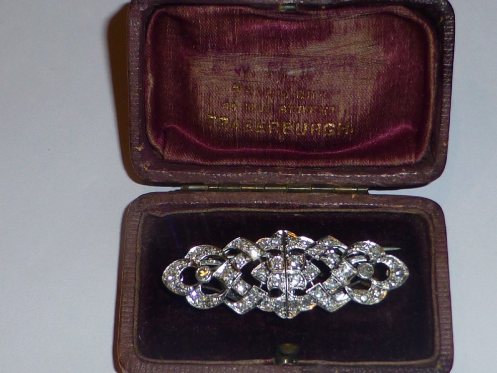 An Art Deco platinum and diamond double clip brooch featuring intricate geometric openwork set with round diamonds. View X
