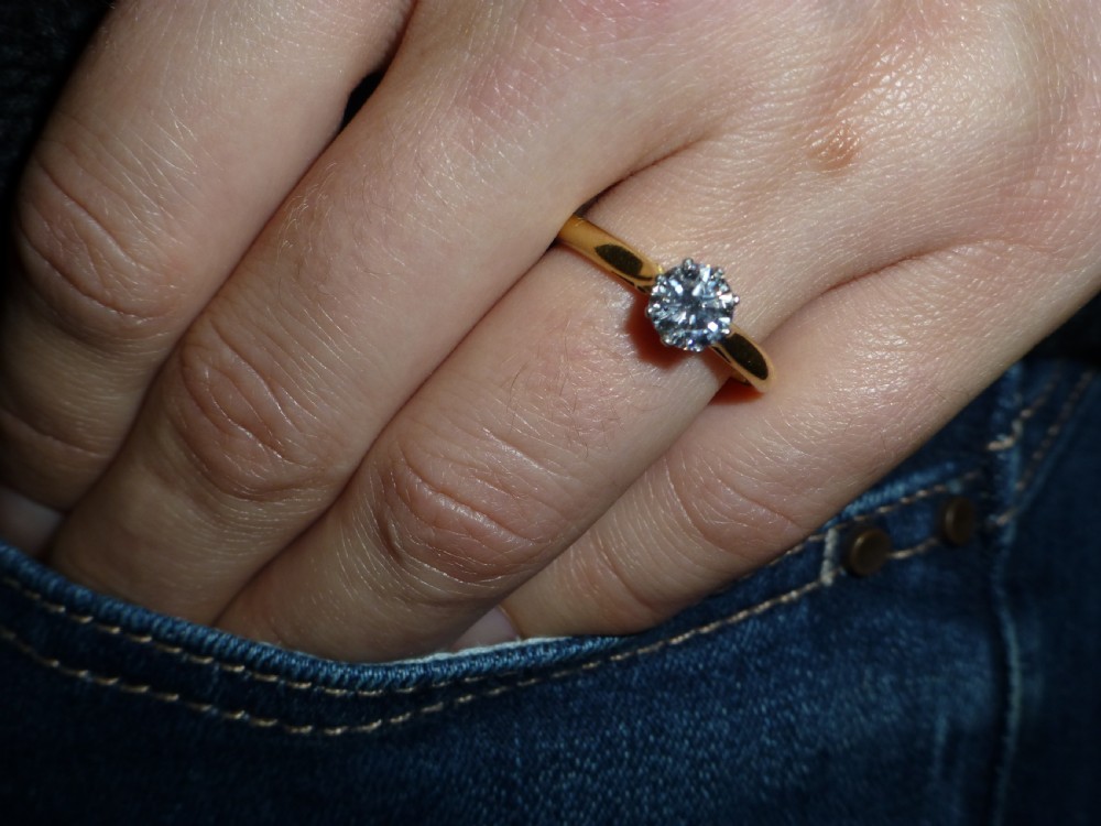 A round brilliant-cut solitaire diamond set in platinum six-prong claws atop an 18ct yellow gold band. View V