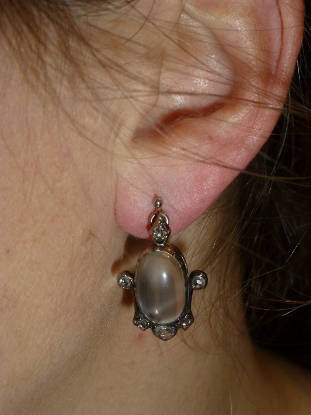 A pair of antique Georgian silver drop earrings featuring central oval cabochon moonstones surrounded by small rose-cut diamonds. View III