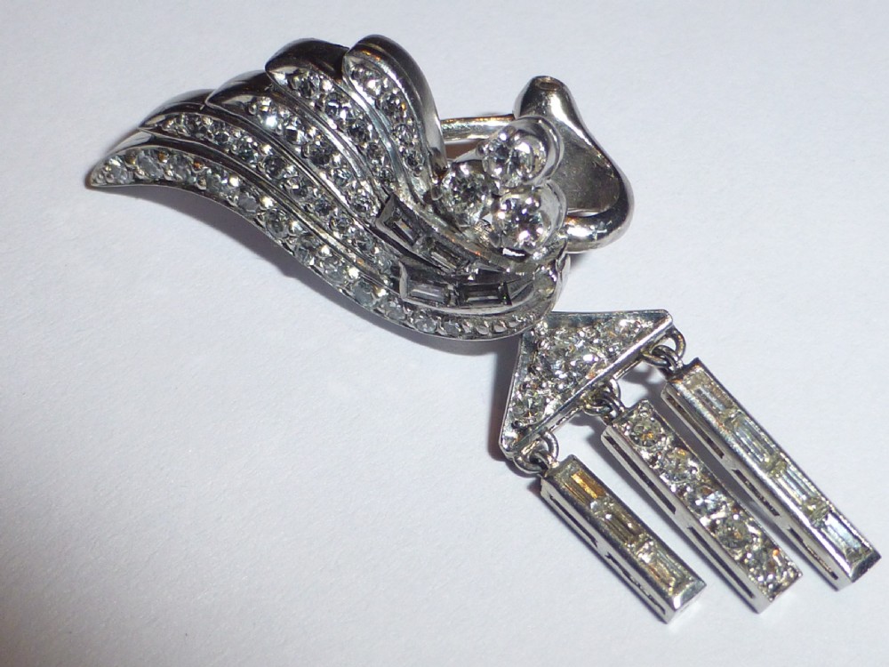 A pair of Art Deco platinum earrings set with round and baguette diamonds, featuring winged tops and detachable geometric drop pendants. View III