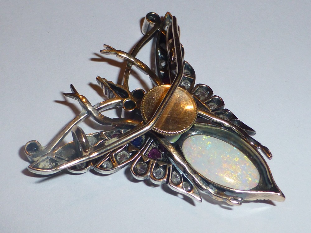Victorian insect brooch set with an oval opal, a turquoise cabochon, sapphires, rubies, and rose-cut diamonds in silver-topped gold. View VI