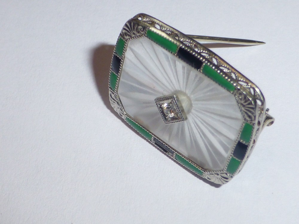 An Art Deco rectangular white gold brooch featuring a starburst-carved translucent rock crystal quartz plaque set with a central diamond, surrounded by green chrysoprase and black onyx inlays. View III