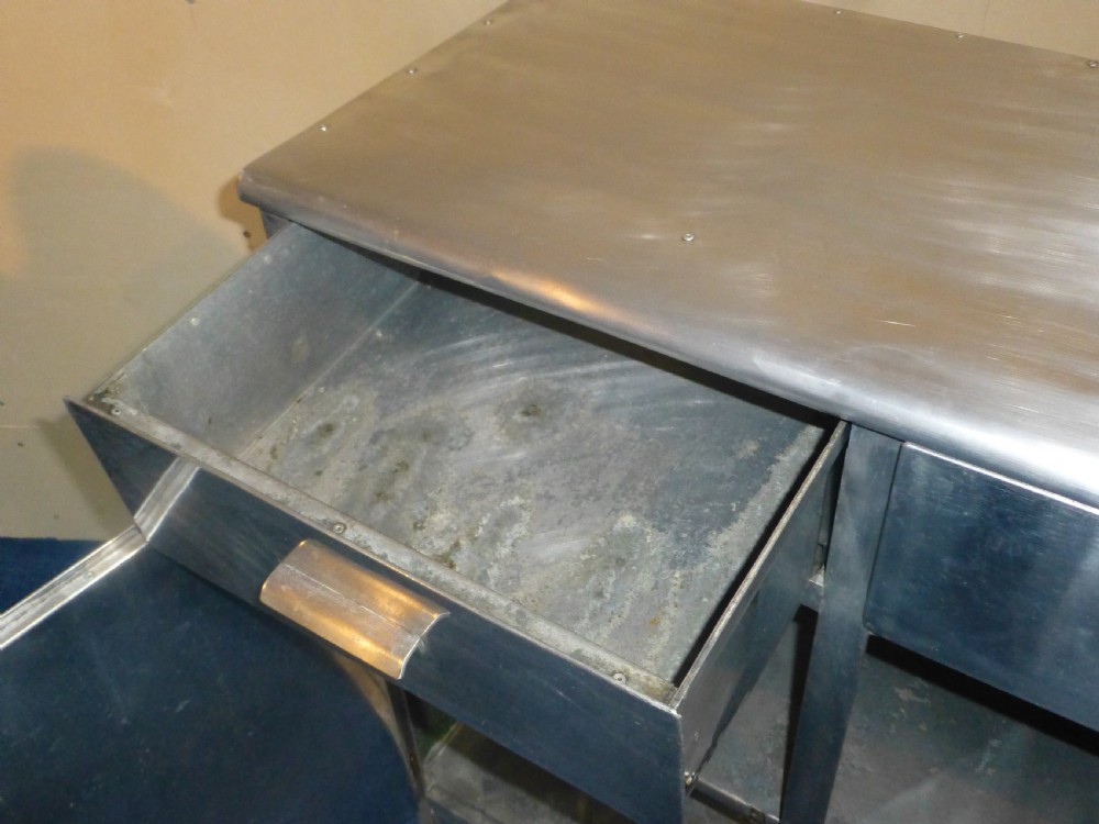 An aluminium metal sideboard featuring two upper drawers, two lower cabinet doors, riveted joinery, and exposed metal hinges. View VIII