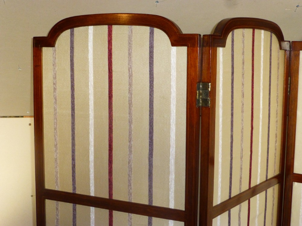 An Edwardian three-panel mahogany folding screen featuring arched top rails and cream striped fabric inserts. View II