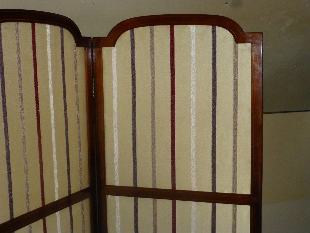 An Edwardian three-panel mahogany folding screen featuring arched top rails and cream striped fabric inserts. View III