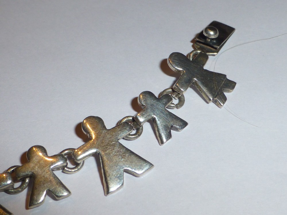 A vintage solid silver link bracelet constructed from a chain of stylized human figures depicting family members. View III