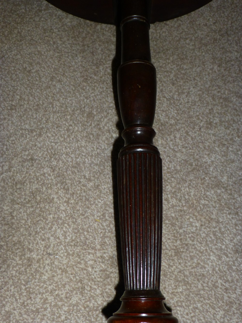 A Regency mahogany circular wine table featuring a moulded rim, a turned reeded pedestal, and three swept tripod legs. View III