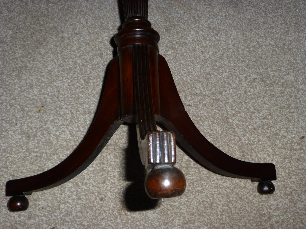 A Regency mahogany circular wine table featuring a moulded rim, a turned reeded pedestal, and three swept tripod legs. View IV