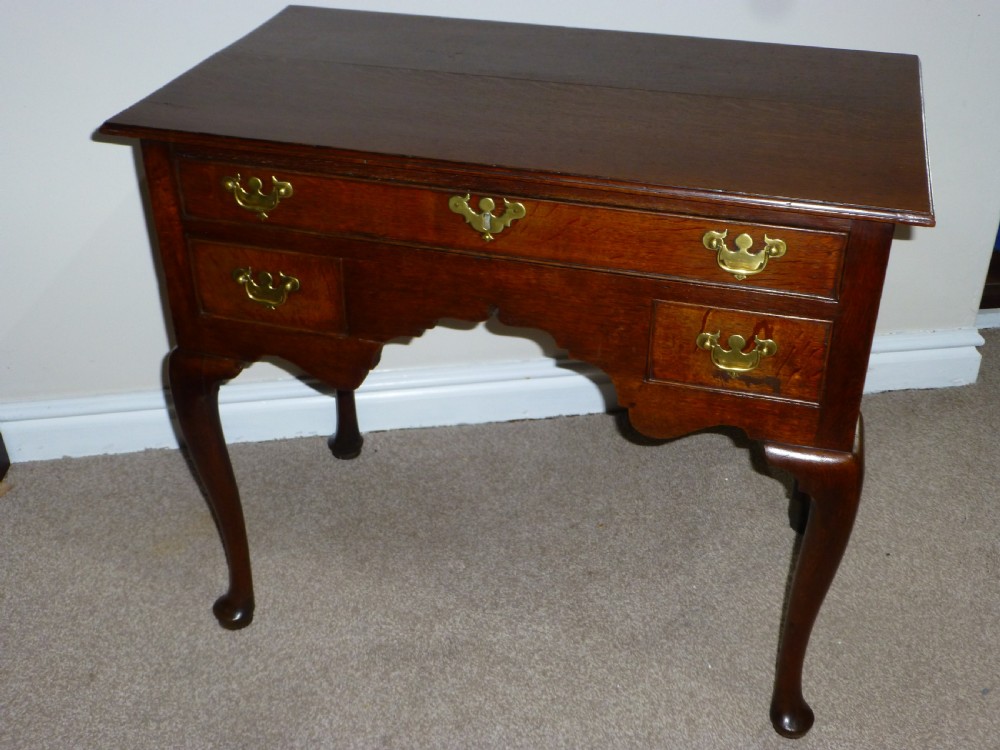 An 18th-century Georgian mahogany lowboy table featuring cabriole legs, brass batwing drawer pulls, and a shaped apron. View II
