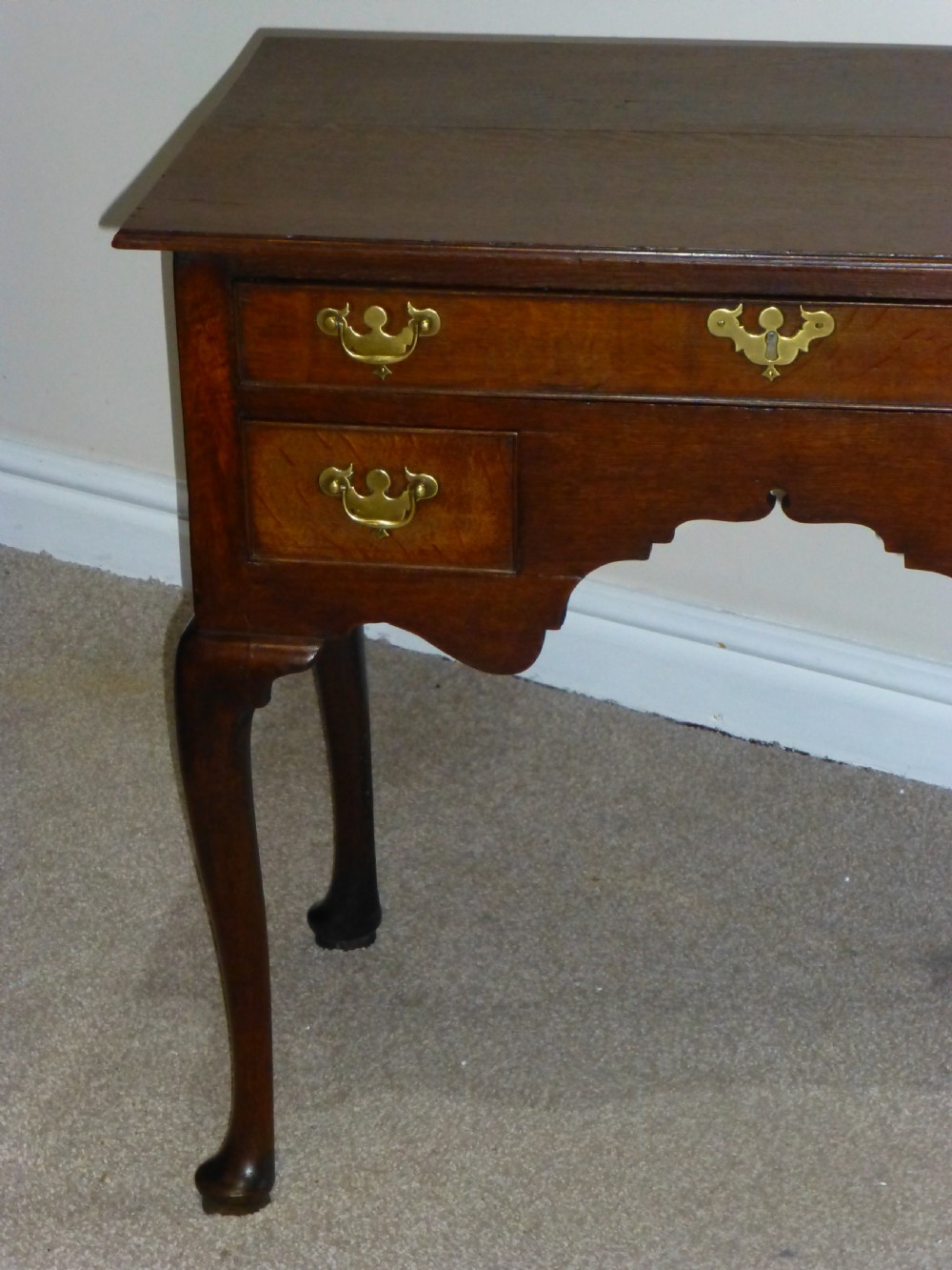 An 18th-century Georgian mahogany lowboy table featuring cabriole legs, brass batwing drawer pulls, and a shaped apron. View VI