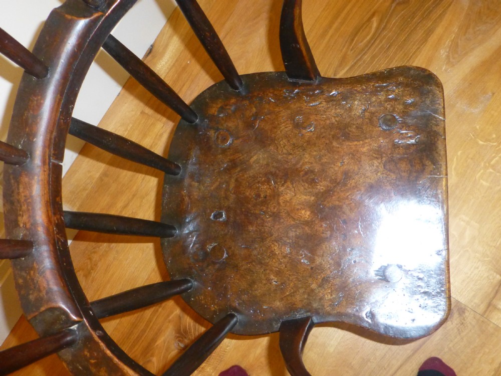 An 18th-century Welsh primitive stick Windsor armchair crafted from dark burr elm and ash with a comb back and turned legs. View II