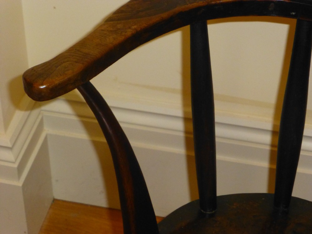 An 18th-century Welsh primitive stick Windsor armchair crafted from dark burr elm and ash with a comb back and turned legs. View V