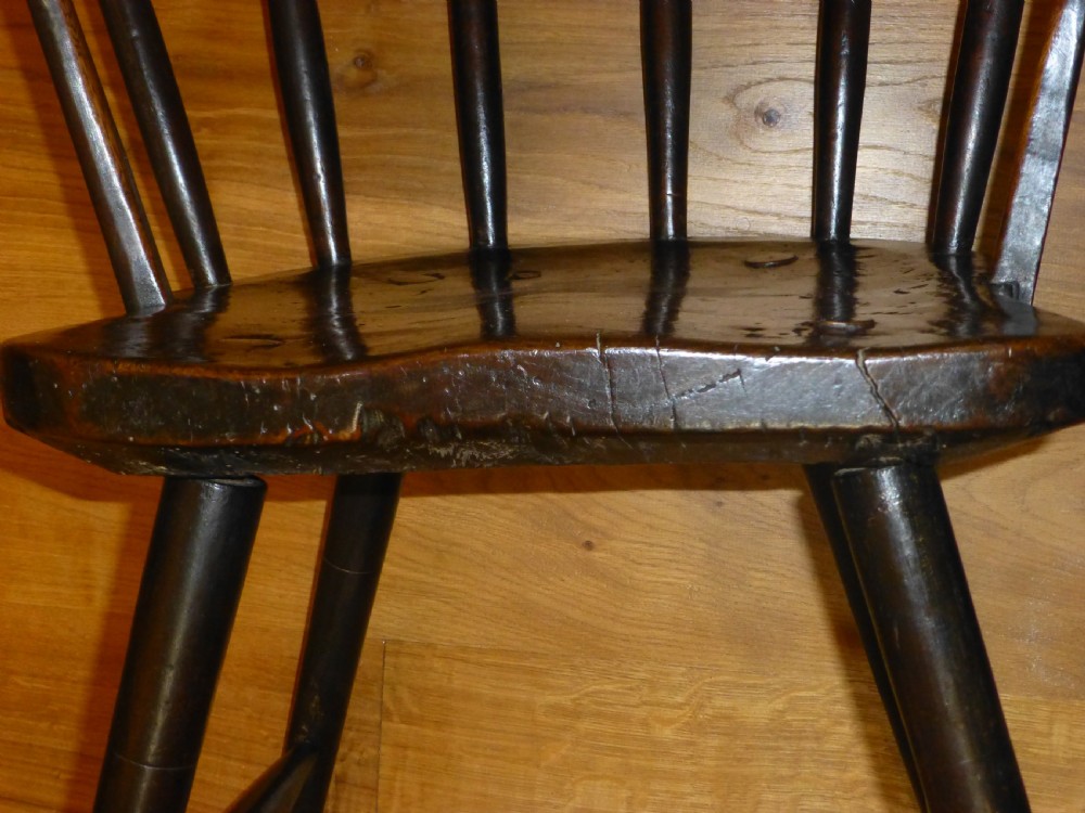 An 18th-century Welsh primitive stick Windsor armchair crafted from dark burr elm and ash with a comb back and turned legs. View VII