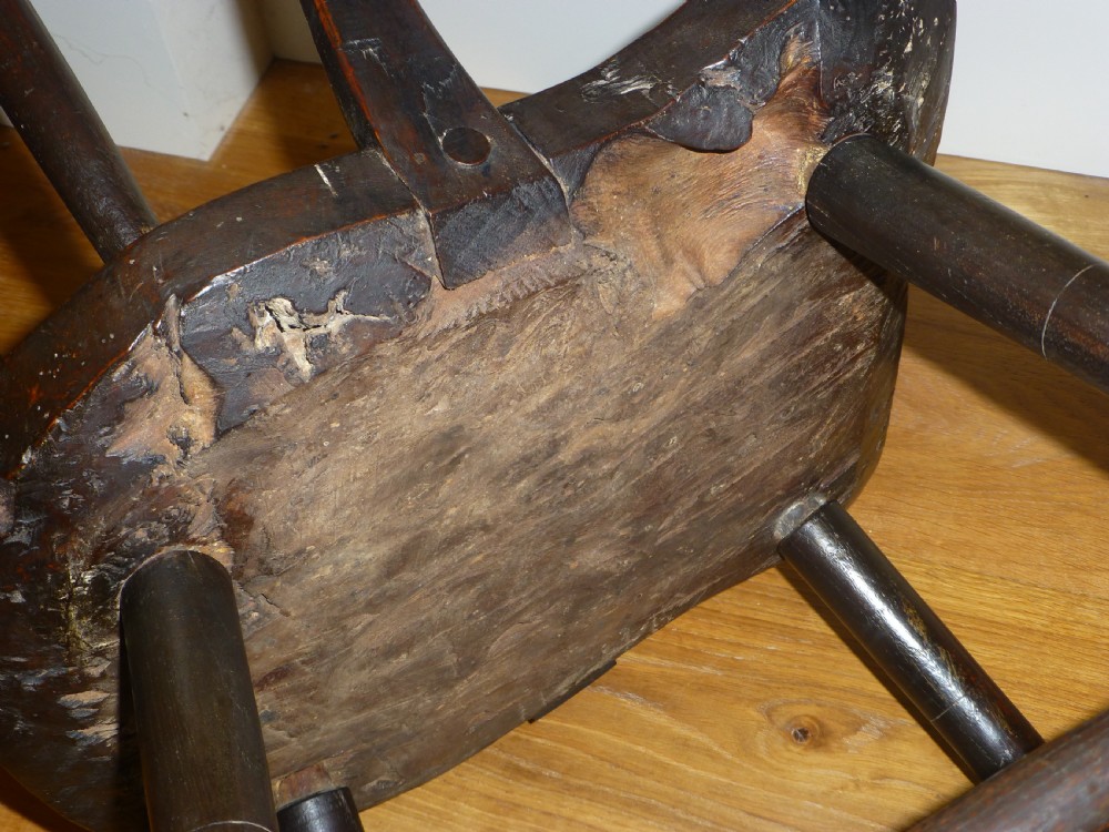 An 18th-century Welsh primitive stick Windsor armchair crafted from dark burr elm and ash with a comb back and turned legs. View VIII