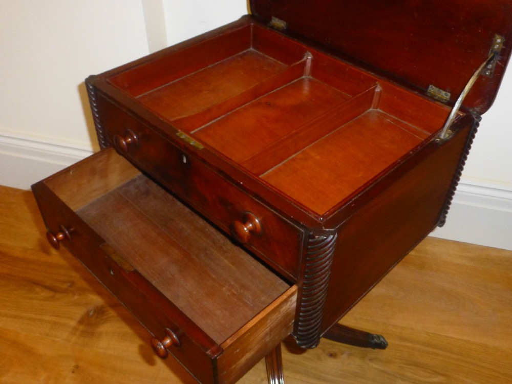 A Regency mahogany work table featuring two drawers with wooden knobs, spirally reeded side columns, and a turned pedestal base on quadruped sabre legs with brass castors. View IV