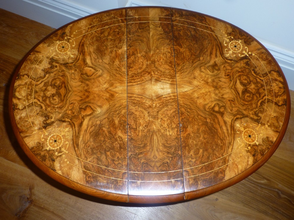 A 19th-century burr walnut Sutherland side table featuring drop leaves with floral marquetry inlay and turned legs on ceramic castors. View III