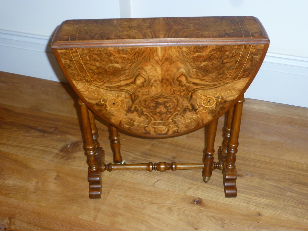 A 19th-century burr walnut Sutherland side table featuring drop leaves with floral marquetry inlay and turned legs on ceramic castors. View VI