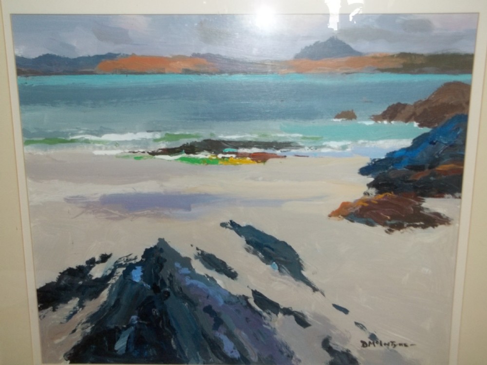 A framed mid-century oil painting depicting a calm shore with a sandy beach, dark coastal rocks, and turquoise water under an overcast sky, signed by Donald McIntyre in the lower right.