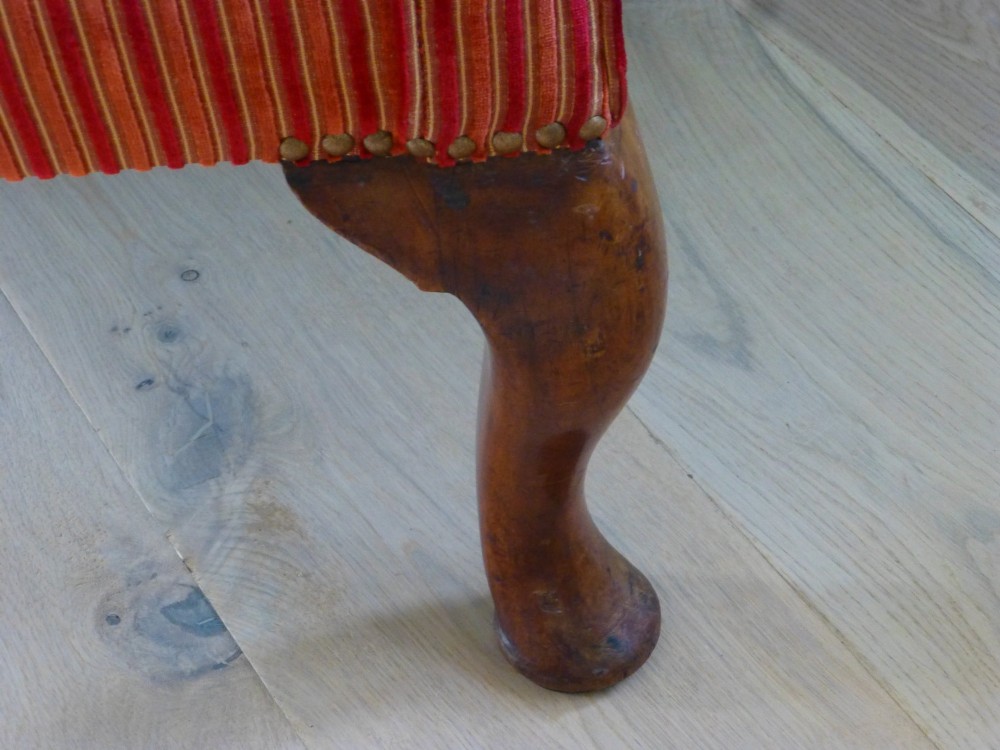 An 18th-century Georgian wingback armchair upholstered in red and gold striped fabric with carved cabriole front legs. View III