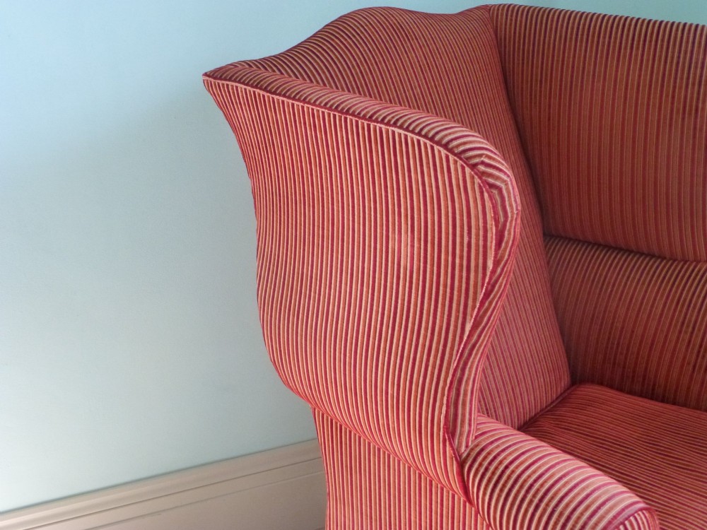 An 18th-century Georgian wingback armchair upholstered in red and gold striped fabric with carved cabriole front legs. View VI