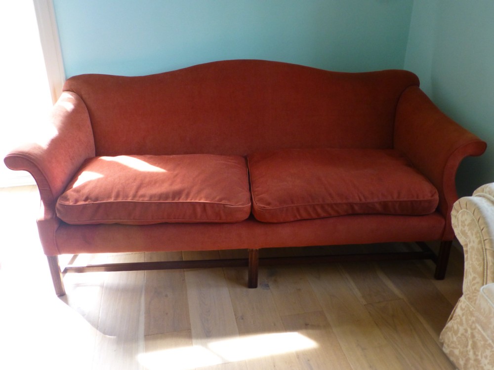 A 19th-century serpentine camel back sofa upholstered in terracotta fabric with mahogany straight legs and stretchers. View II