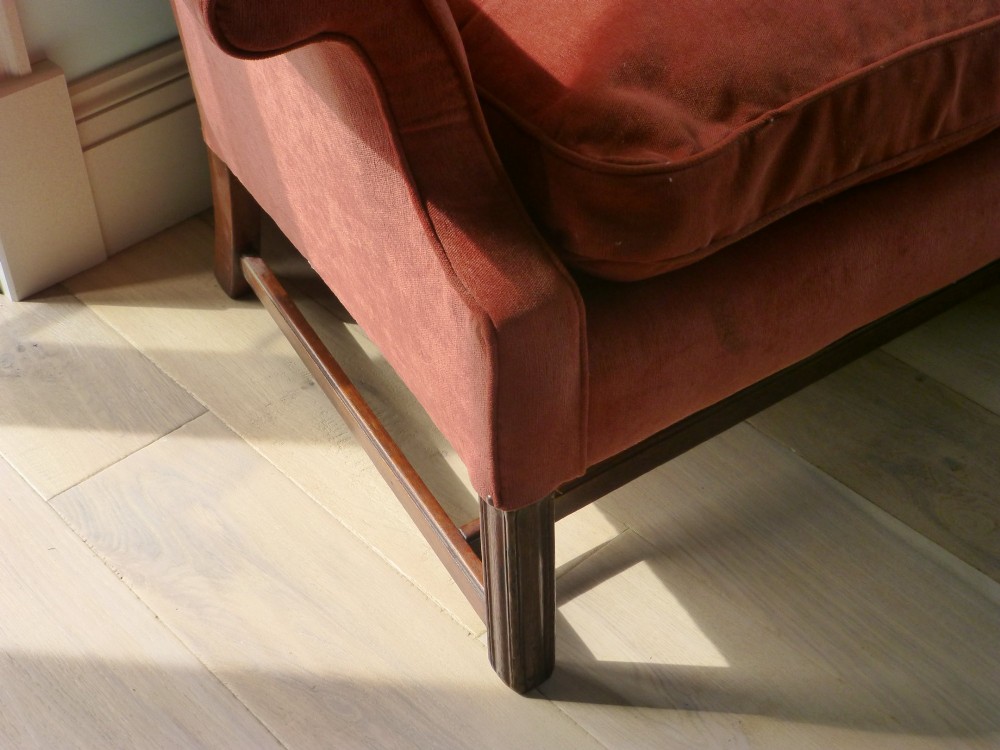 A 19th-century serpentine camel back sofa upholstered in terracotta fabric with mahogany straight legs and stretchers. View III