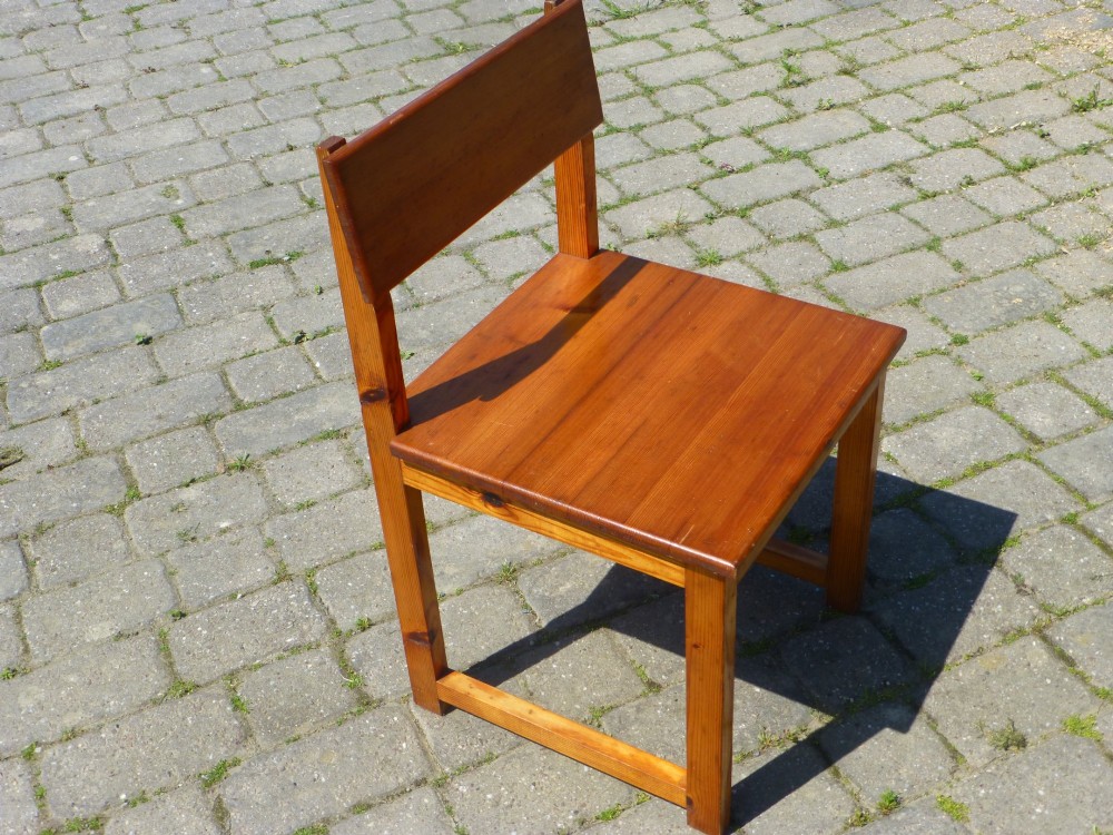 A set of six warm amber-toned solid pine dining chairs featuring flat rectangular backrests and solid square panel seats. View II