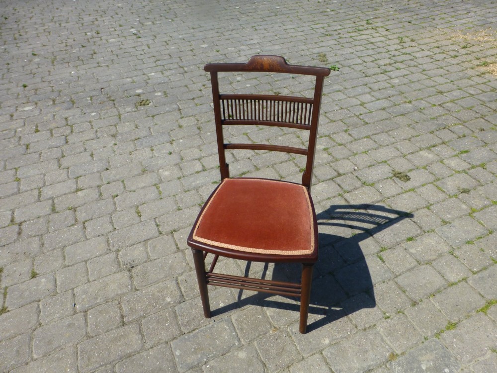 A set of four dark mahogany Edwardian dining chairs featuring decorative crest rail inlay and terracotta velvet seats. View III