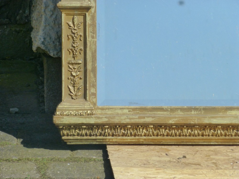A large rectangular nineteenth-century gilt overmantel mirror featuring fluted pilasters, rosette corner embellishments, and a central leaf cresting. View VI