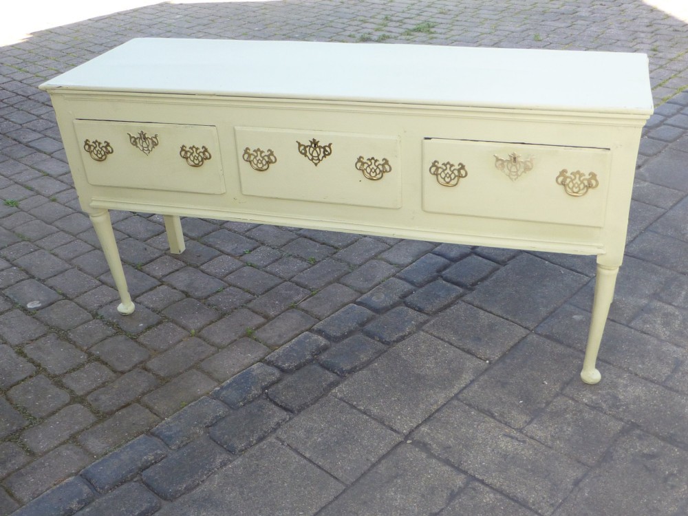 An 18th-century Georgian painted oak dresser base featuring three drawers with decorative brass handles, supported by slender legs with shaped side aprons. View IV