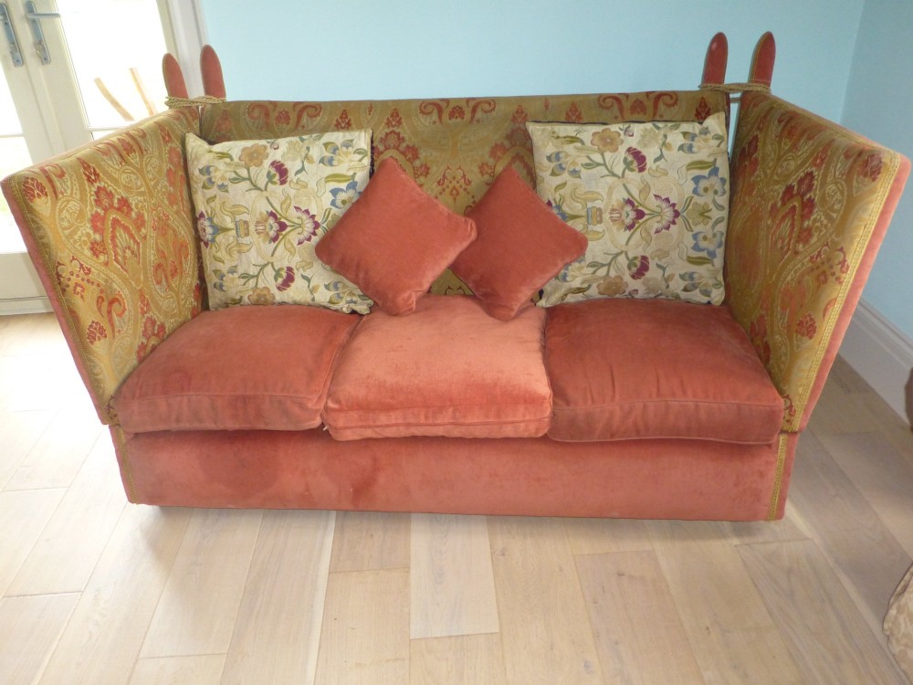 A nineteenth-century Victorian Knole sofa upholstered in terracotta velvet with patterned woven fabric lining, featuring high adjustable sides attached to carved corner finials with cords. View II