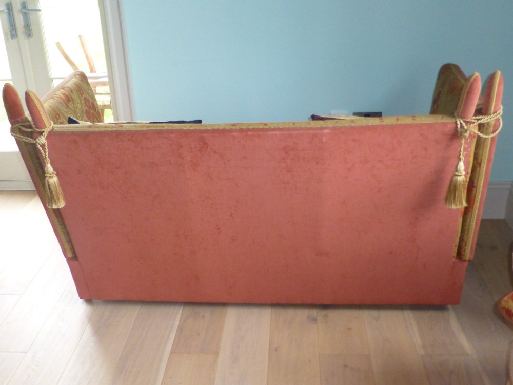 A nineteenth-century Victorian Knole sofa upholstered in terracotta velvet with patterned woven fabric lining, featuring high adjustable sides attached to carved corner finials with cords. View III