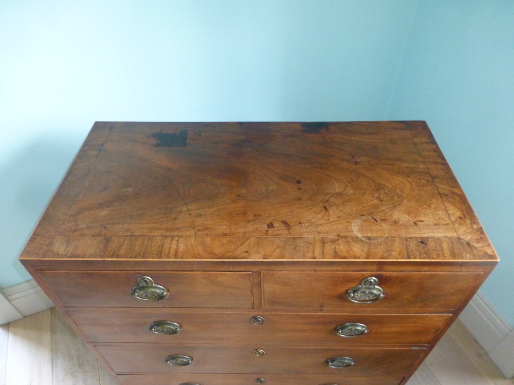 A late eighteenth-century Georgian mahogany chest of drawers with two short drawers over three long graduated drawers, featuring line inlay and oval brass handles. View II