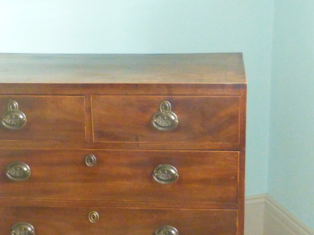 A late eighteenth-century Georgian mahogany chest of drawers with two short drawers over three long graduated drawers, featuring line inlay and oval brass handles. View III