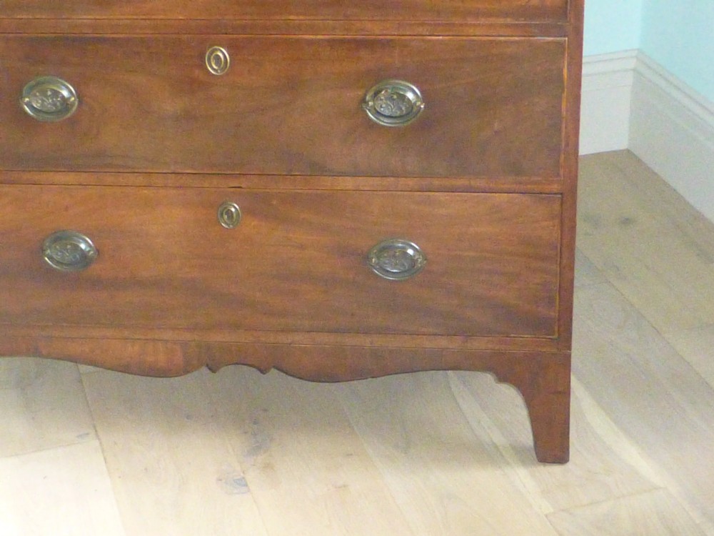 A late eighteenth-century Georgian mahogany chest of drawers with two short drawers over three long graduated drawers, featuring line inlay and oval brass handles. View IV