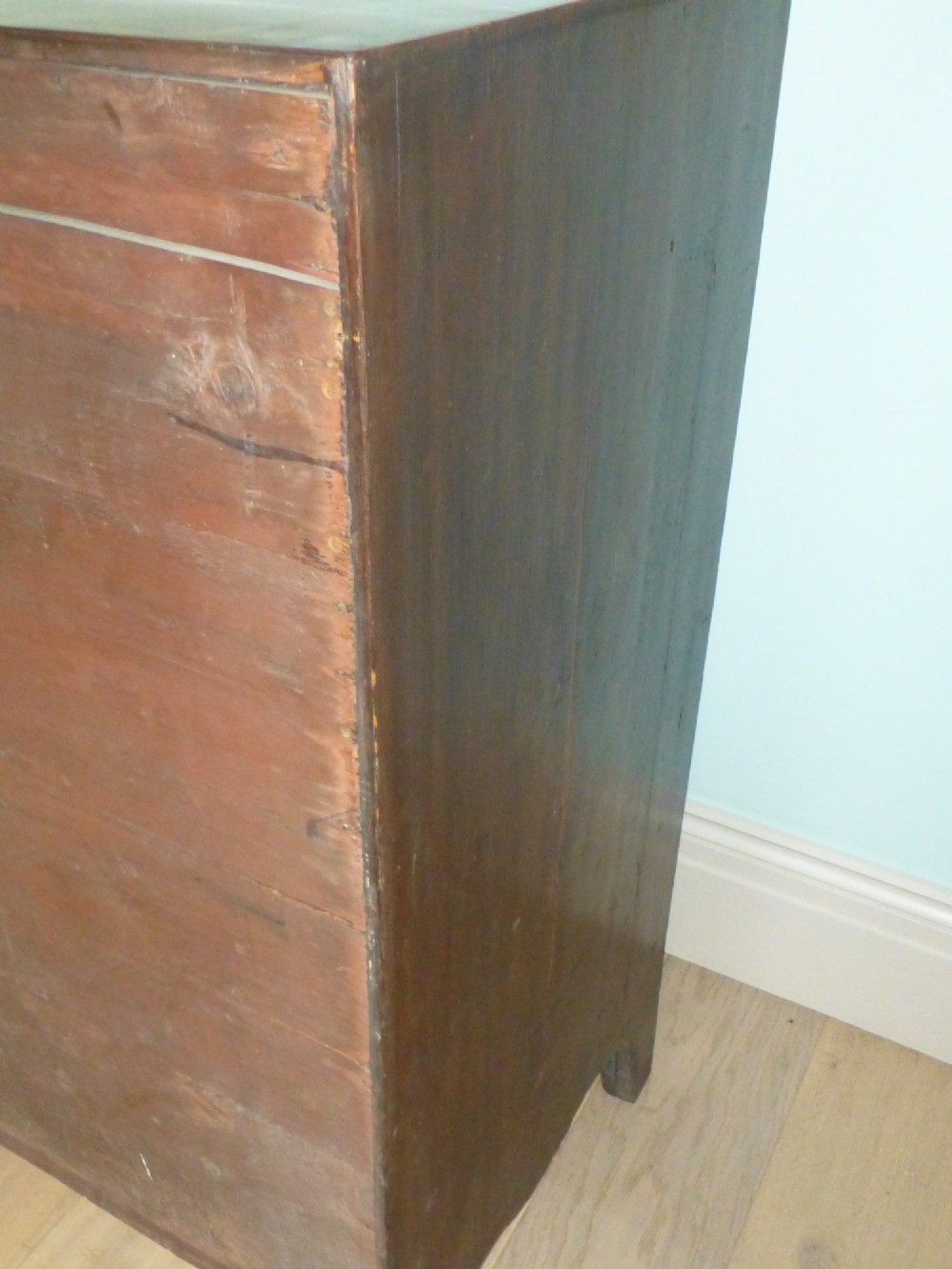 A late eighteenth-century Georgian mahogany chest of drawers with two short drawers over three long graduated drawers, featuring line inlay and oval brass handles. View V