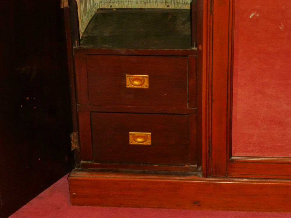 A mid-19th-century Victorian triple wardrobe made of rich burr walnut, featuring a central full-length mirror door flanked by two carved panelled doors. View V