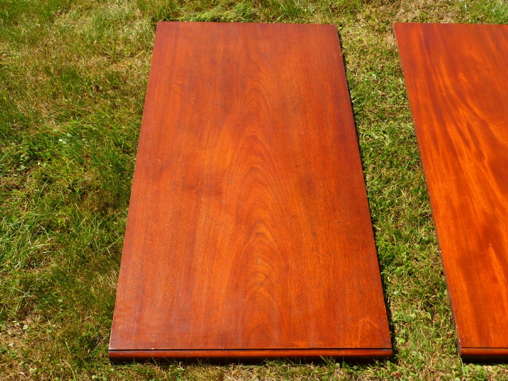 A large Regency extending mahogany dining table featuring a polished rectangular top, three extension leaves, and turned wood legs. View IV