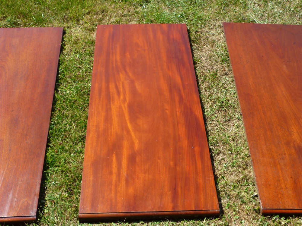 A large Regency extending mahogany dining table featuring a polished rectangular top, three extension leaves, and turned wood legs. View V